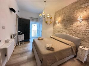 Un dormitorio con una cama y una pared de ladrillo. en Cozy Sea View Flat with Private 83 sq Rooftop, Balcony, and BBQ in the Old Town, en Vieste