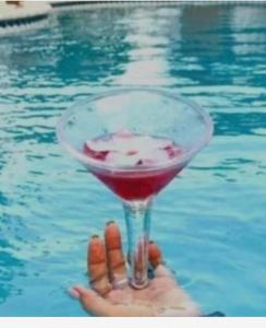 a person holding a drink in the swimming pool at B&B Harmony in Oranjestad +14 photos