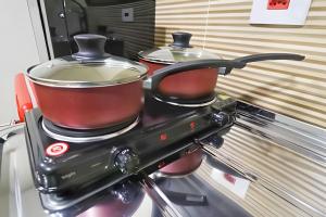 two pots and pans sitting on top of a stove at Estúdio II - Franco da Rocha - Completo in Franco da Rocha