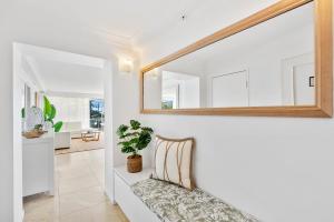 a living room with a couch and a mirror at Sun-Kissed Escape - Broadbeach Gem - Hosted by Coastal Letting Co. in Gold Coast
