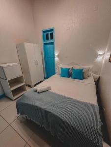 a bedroom with a large bed with blue pillows at Piratas da Vila in Jericoacoara