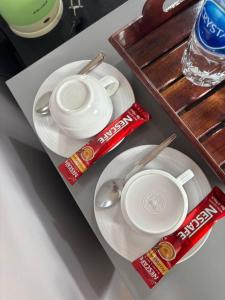 una mesa con dos platos blancos y dos tazas y palillos en เฮือนฮิมน้ำ รีสอร์ท, 