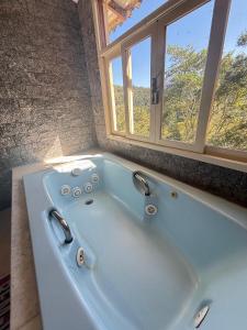 a large bath tub in a room with a window at Pousada e Spa Vrindávana in Teresópolis +74 photos