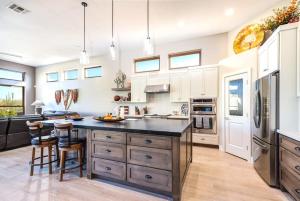 a kitchen with a large island with a black counter top at Scottsdale Luxury Heated Pool Desert Views For 6 in Scottsdale