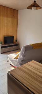 una camera da letto con un letto e una TV a schermo piatto di studio 20m a Saint-Martin-des-Noyers