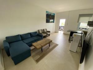 a living room with a blue couch and a table at Casa Kappa alibutsweg 15 in Paramaribo