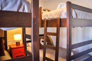 a room with three bunk beds and a lamp at HOM I Edif Valle Blanco 3D2B jacuzzi SKI IN y OUT VB104 in Lo Barnechea