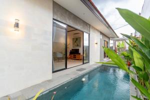 a swimming pool in front of a house at Villa Uma Tegal Cemagi in Cemagi