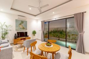 a living room with a table and chairs at Villa Uma Tegal Cemagi in Cemagi