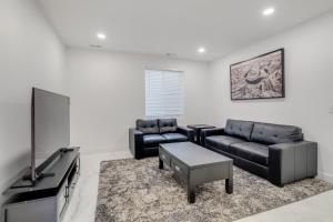un soggiorno con mobili neri e TV a schermo piatto di 16 Mi to Dtwn Denver Modern Apt with Patio a Denver
