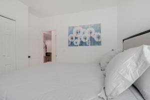 una camera da letto bianca con un letto e uno specchio di 16 Mi to Dtwn Denver Modern Apt with Patio a Denver