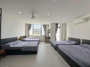 a bedroom with two beds and a window at Khách sạn Na Na Thiên Trà in Quận Ðăng (2)