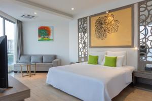 a bedroom with a large white bed with green pillows at Swandor Cam Ranh Resort-Ultra All Inclusive in Cam Ranh +67 photos