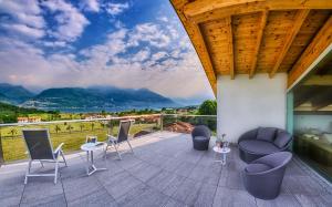 un patio con sedie, tavoli e vista sulle montagne di Rainbow Holiday Apartments Lake Como a Colico