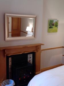 a mirror over a fireplace in a bedroom at Gardeners Cottage B and B in Bakewell
