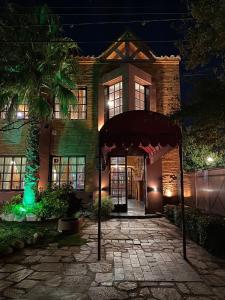 Un edificio con un toldo delante por la noche. en Posada Alpenrose Neu, en Villa Carlos Paz