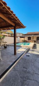 a patio with a pavilion and a swimming pool at CasaPraiaSol1 in Rio das Ostras