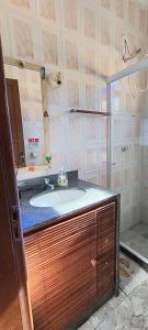 a bathroom with a sink and a shower at CasaPraiaSol1 in Rio das Ostras