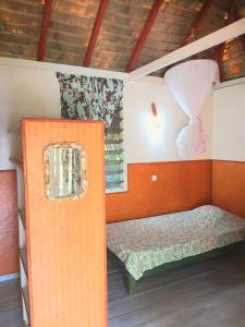 a small bedroom with a bed and a window at HUAHINE - Bungalow Perroquet in Fare