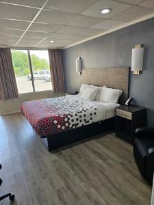 a hotel room with a bed and a chair at The Edyn Motel in Wytheville