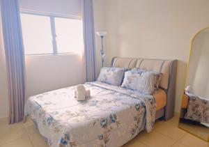 a bedroom with a bed with a teddy bear on it at The Alanis GG Suites in Sepang