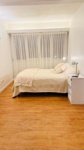 a bedroom with a large bed and a wooden floor at Ola MdP in Mar del Plata +18 photos