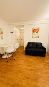 a living room with a black couch and a table at Ola MdP in Mar del Plata