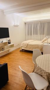 a bedroom with a bed and a chair and a tv at Ola MdP in Mar del Plata
