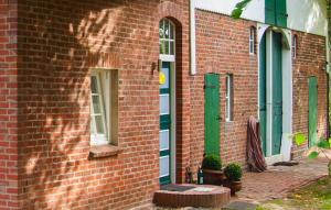 a red brick building with green doors and windows at Beautiful Apartment In Wingst in Wingst