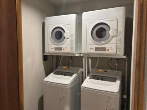 three washing machines and a washer and dryer in a room at SEN RETREAT TAKIJIRI - Kumano Kodo Gateway in Tanabe