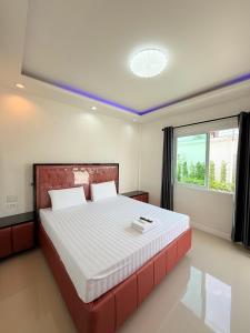 a bedroom with a large bed and a window at โรงแรม พรีโม รีสอร์ท in Ban Bang Phang