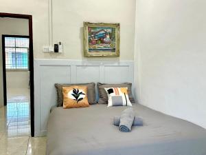 a bedroom with a bed with pillows on it at Vintage-Living 2Storey Haus12Pax in Simpang Ampat