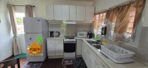 a kitchen with a white refrigerator and a sink at Villa Tutilia in Willemstad