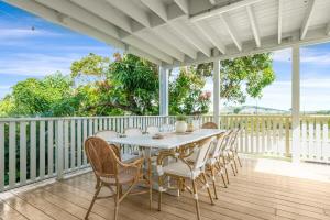 a table and chairs on a porch with a fence at Sea Sage Cottage 4703 in Yeppoon