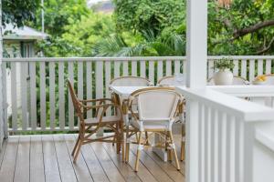 a porch with three chairs and a table on a deck at Sea Sage Cottage 4703 in Yeppoon