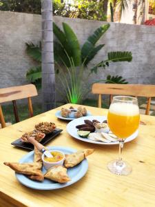 a table with two plates of food and a glass of orange juice at Espaço conforto e tranquilidade CASAVEG in Canoa Quebrada +13 photos