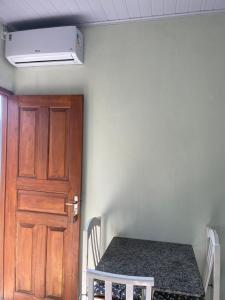 a room with a table and a wooden door at Mini casa perto BC, Penha in Itajaí