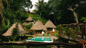ein Resort mit einem Pool und einigen Hütten in der Unterkunft Tawaca Ecohotel in Calabazo