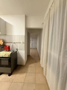 Una cocina con estufa y un pasillo con cortinas. en Departamento Ideal Resistencia Chaco, en Resistencia