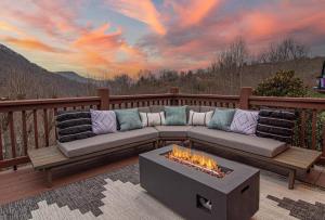 un sofá sentado en una terraza con una hoguera en Mtn Views, HotTub, Sauna, Outdoor Theater, FirePit, en Waynesville