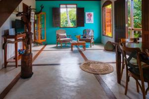 un soggiorno con pareti blu e tavolo e sedie di Casa Bela do Sol a Ilha de Boipeba
