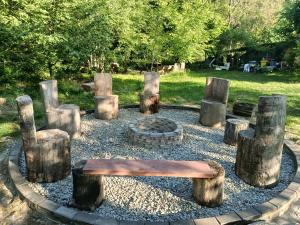 a park with a bench and logs and a fire place at Complex Adela Transfăgărășan in Cârțișoara