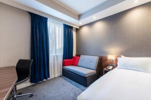 a hotel room with a bed and a chair at Holiday Inn Express Aberdeen Airport by IHG in Dyce