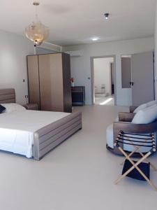 a bedroom with a bed and a couch and a chair at Luxury Villa with Ocean Views ! Minimum booking 1 week in Cascavelle