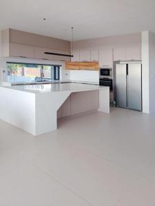 a white kitchen with a large white counter top at Luxury Villa with Ocean Views ! Minimum booking 1 week in Cascavelle