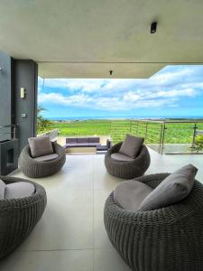 a living room with couches and chairs and a large window at Luxury Villa with Ocean Views ! Minimum booking 1 week in Cascavelle