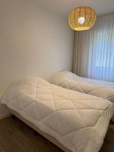 a bed in a bedroom with a chandelier at Apartamento Condominio Nogueira Petrópolis rj #3 in Bom Sucesso