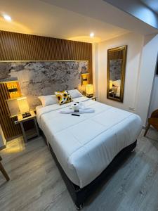 a large white bed in a room with two lamps at Yanahuara HOTEL PLAZA in Yanahuara
