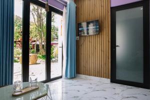 a room with a glass door and a glass table at Homestay PHƯỢNG HOÀNG in Hue