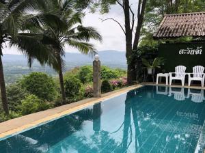 a swimming pool with chairs and a view at Tawanja Resort in Ban Mai